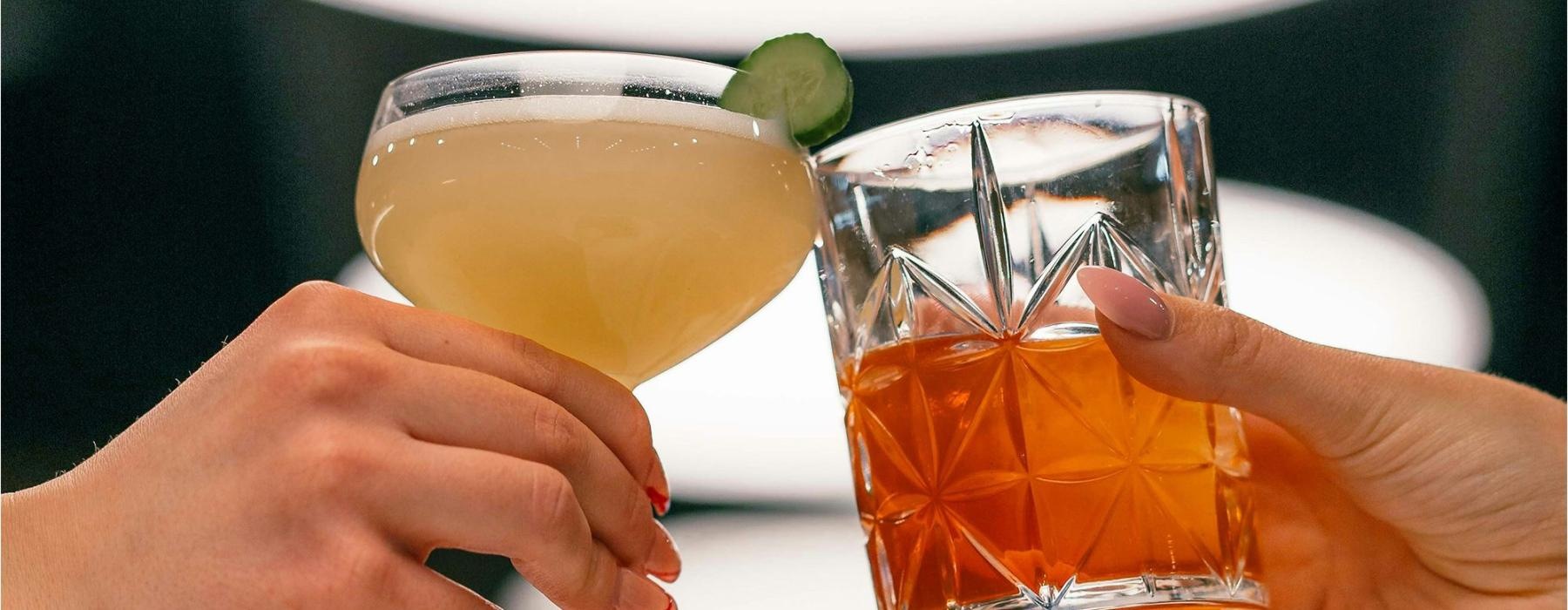hands holding glasses with cocktails