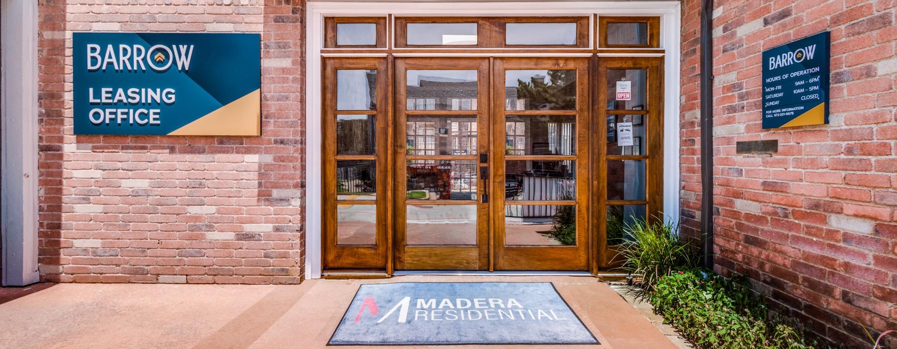 a building with a sign in front that reads leasing office